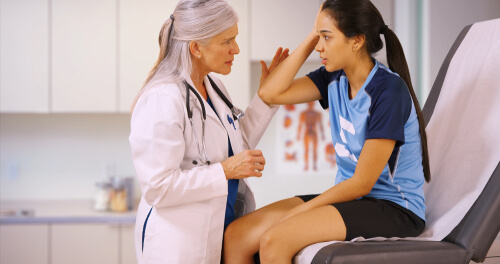 doctor looking at female athlete patient